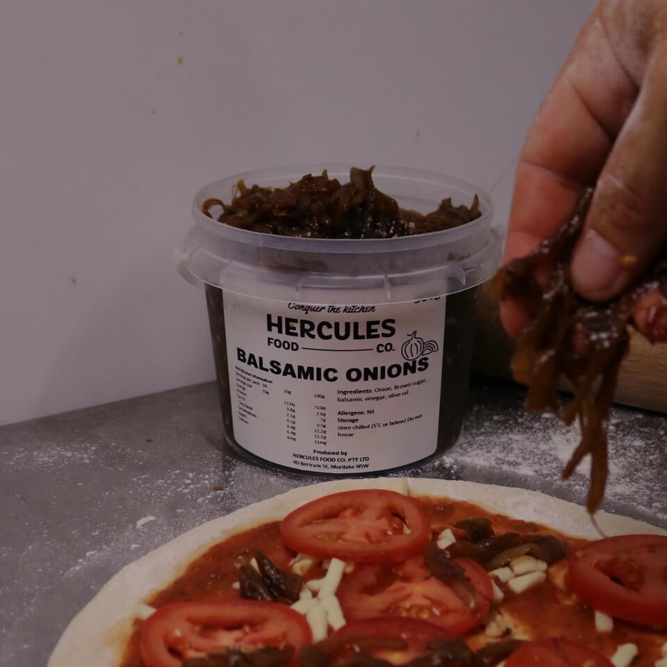 Balsamic onions from a Hercules tub going onto a pizza